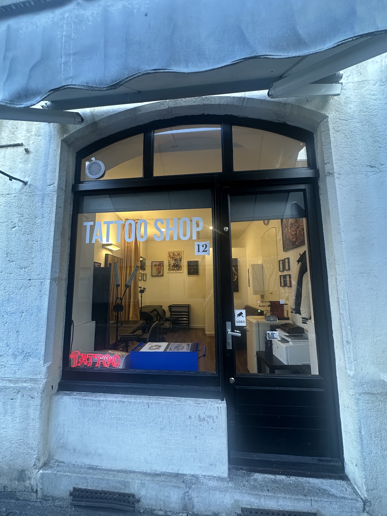 Fa&ccedil;ade du studio Quartier 12 Tattoo de nuit, lumi&egrave;re chaude &agrave; travers la vitrine vo&ucirc;t&eacute;e, Rue du M&ocirc;le 12, Gen&egrave;ve